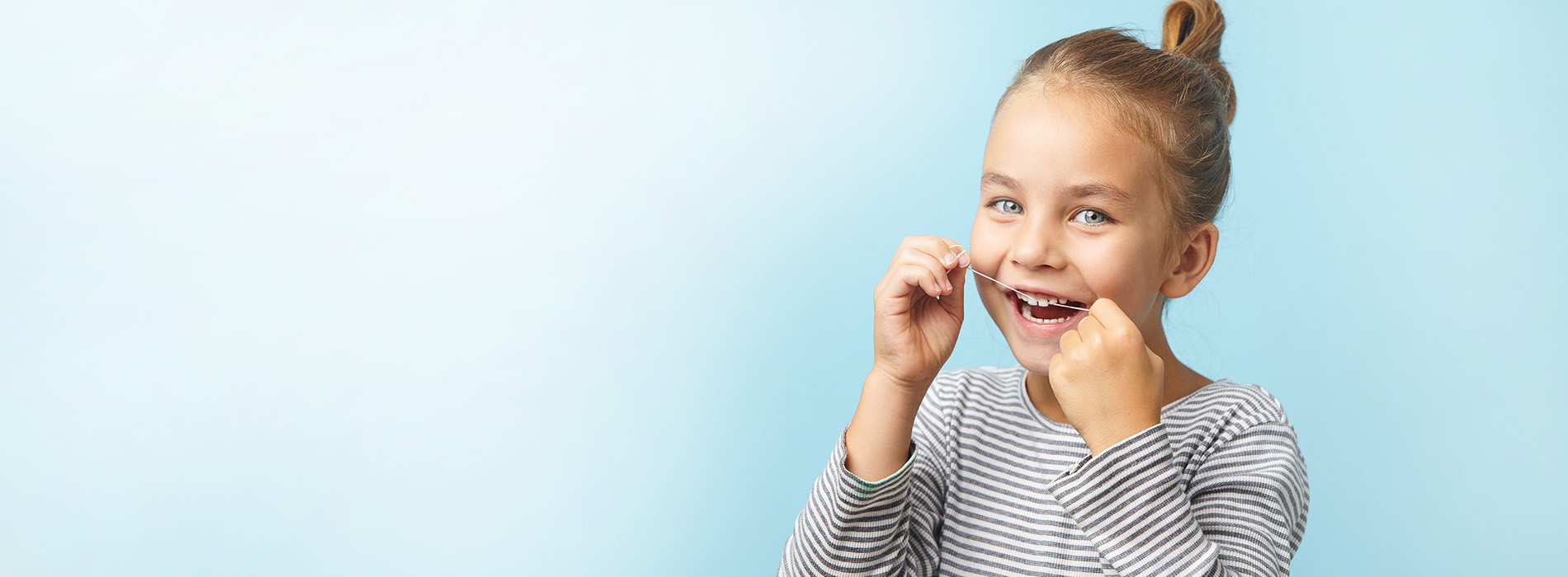 A young child with a surprised expression, holding their hands up near their face, against a light blue background.